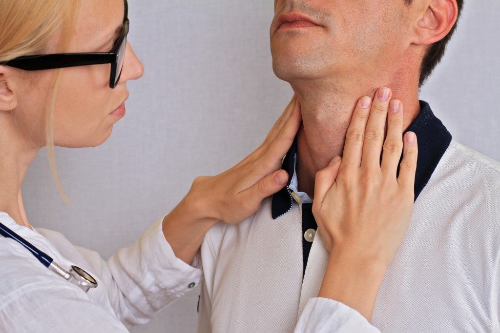 Doctor touching a man's neck