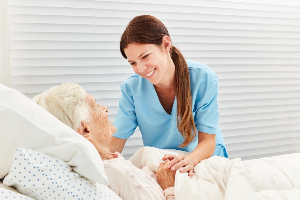 nurse attends to a woman in palliative care