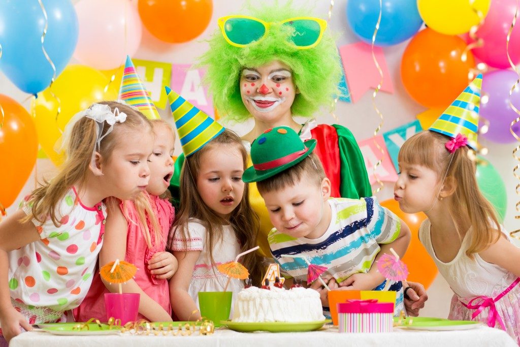 kids blowing a birthday cake