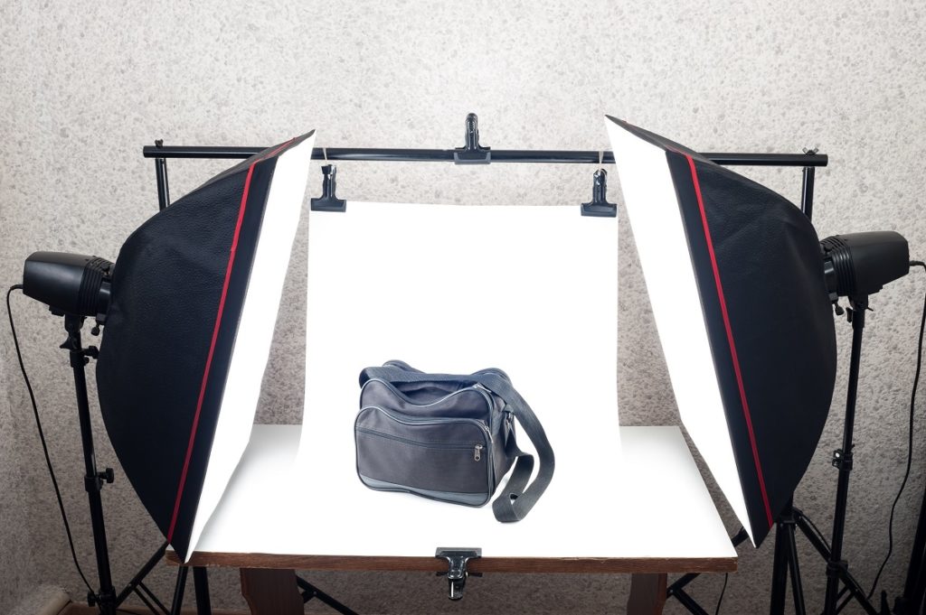 a black messenger bag being photographed in a studio