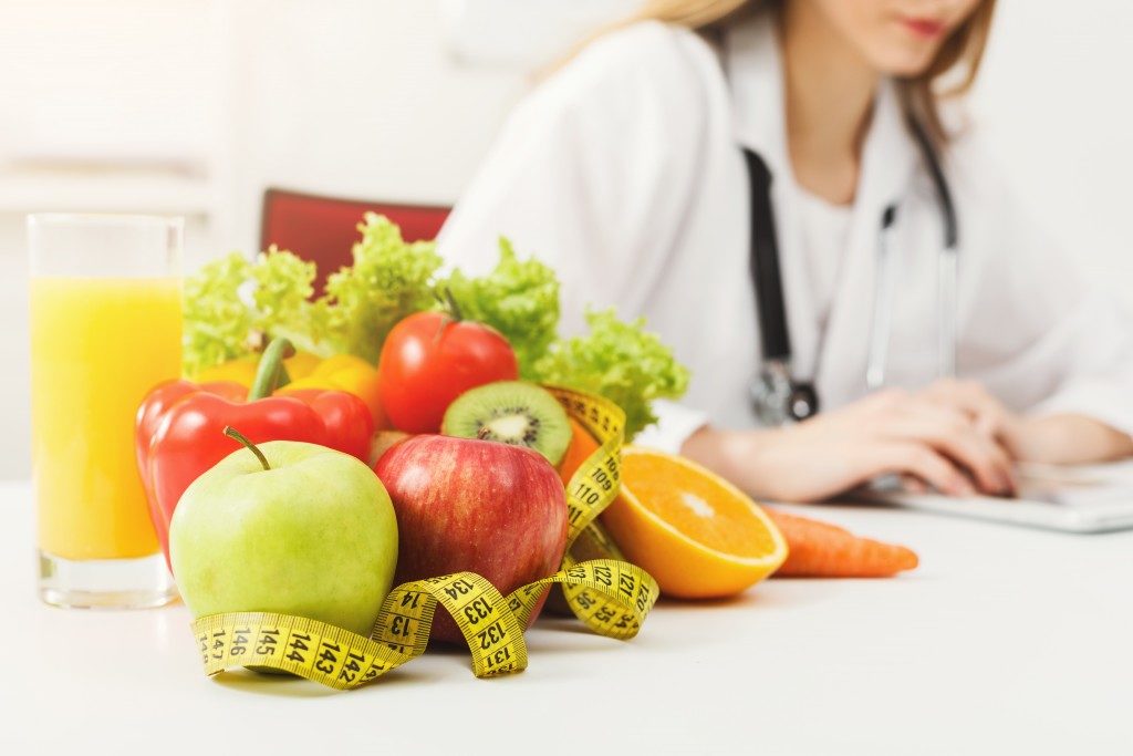 fruits next to measuring tape and doctor