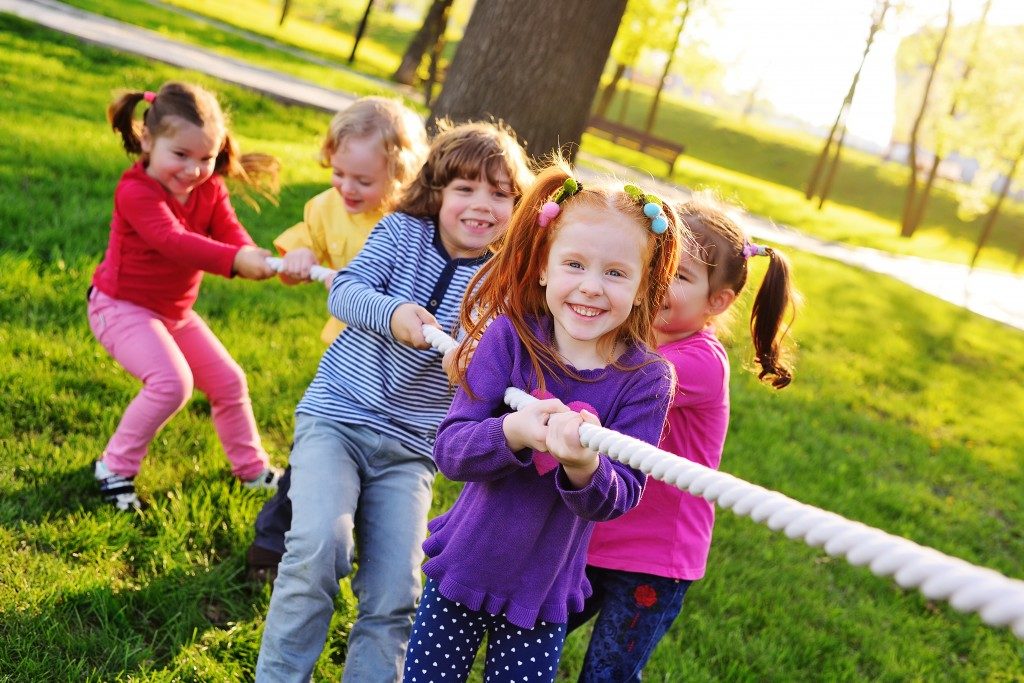 kids pulling a rope in the park