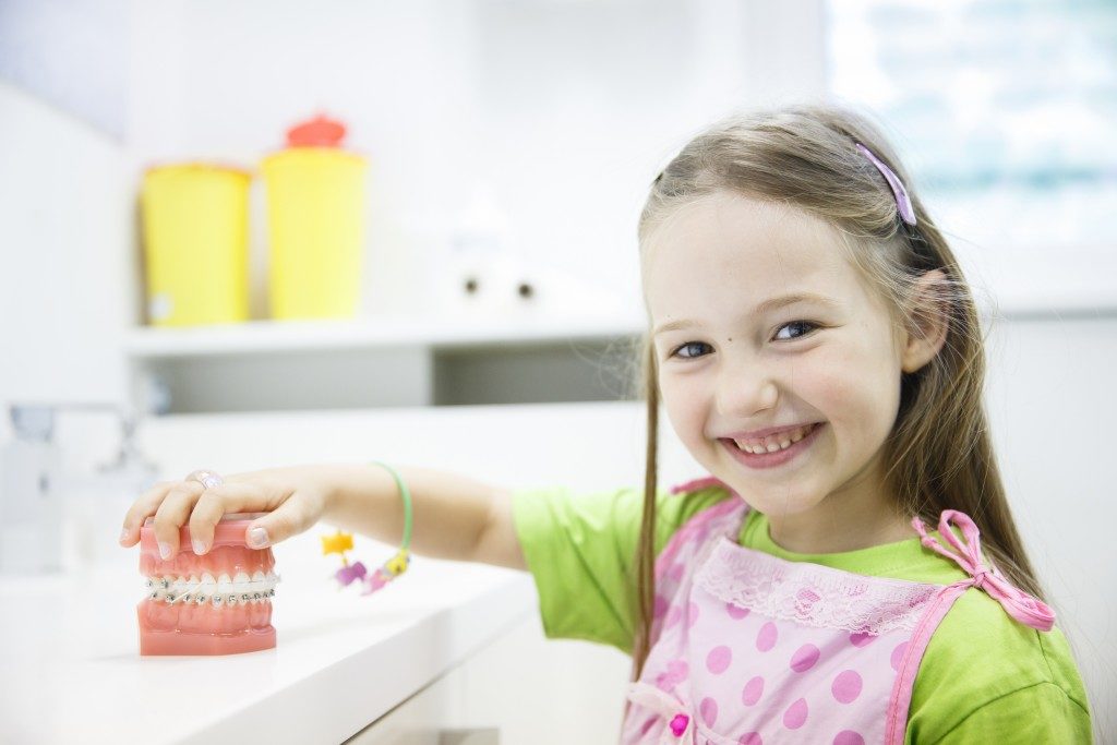 child at the dental office with teeth model