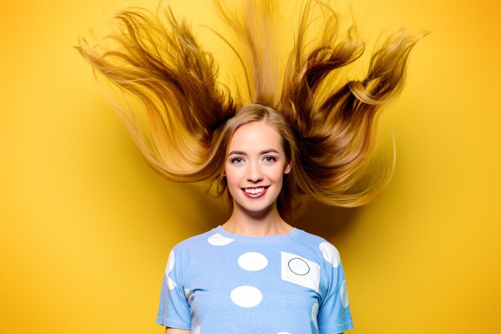 woman with blond hair over a yellow background