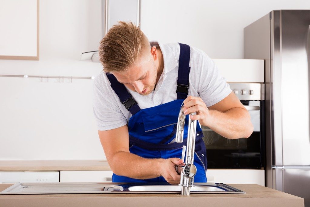 plumber fixing the faucet