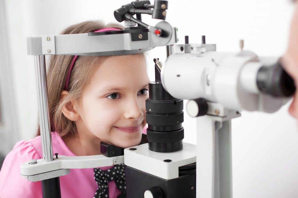 Optometrist performing visual field test of young girl