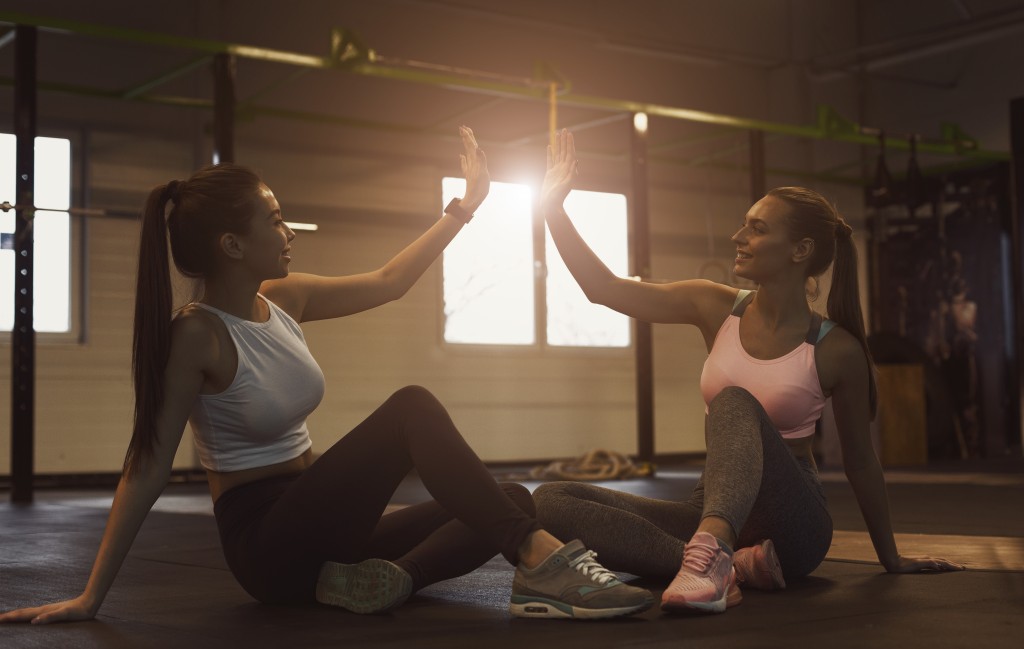 Two women doing a high-five after working out