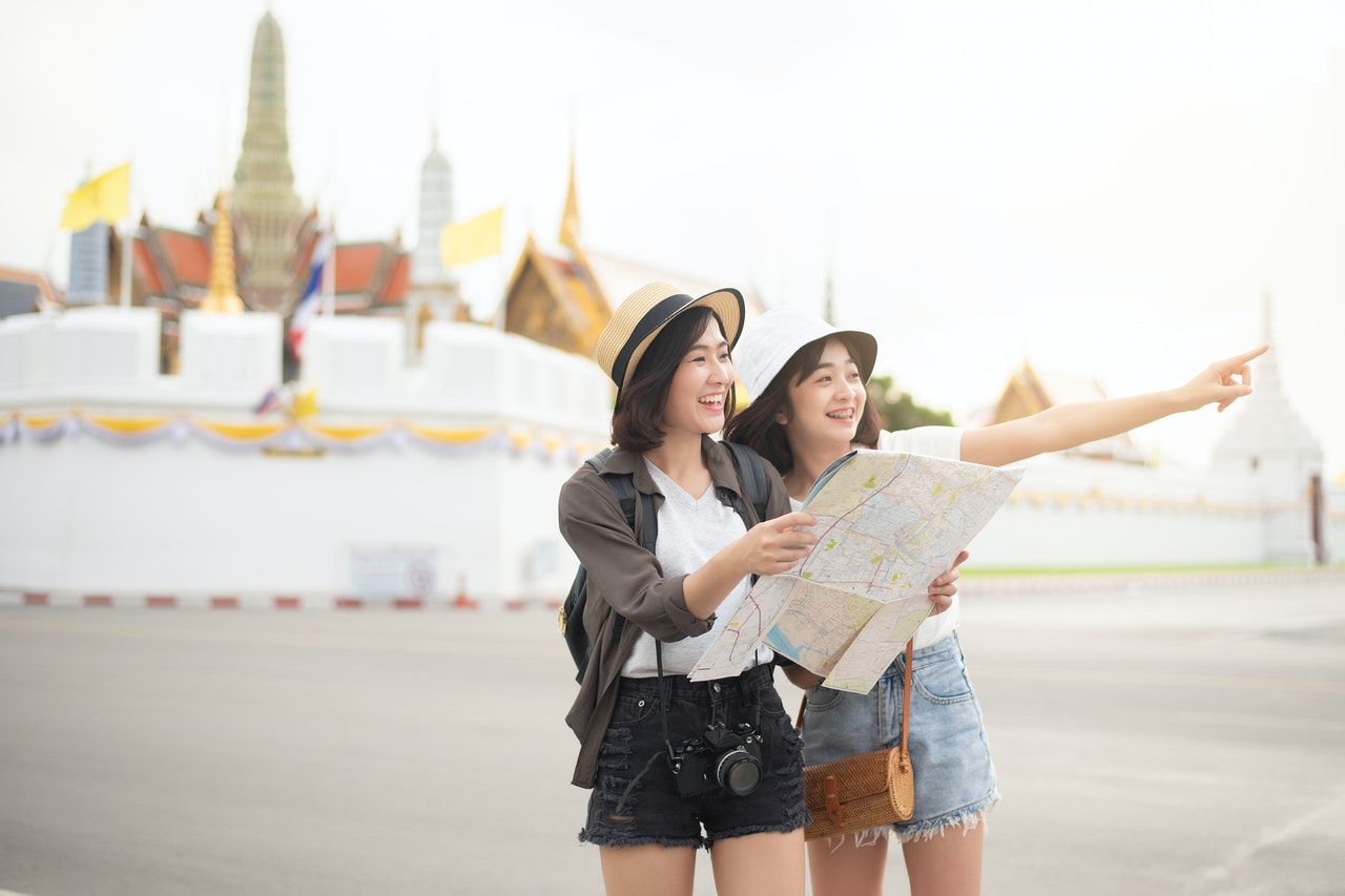 2 women holding map travelling