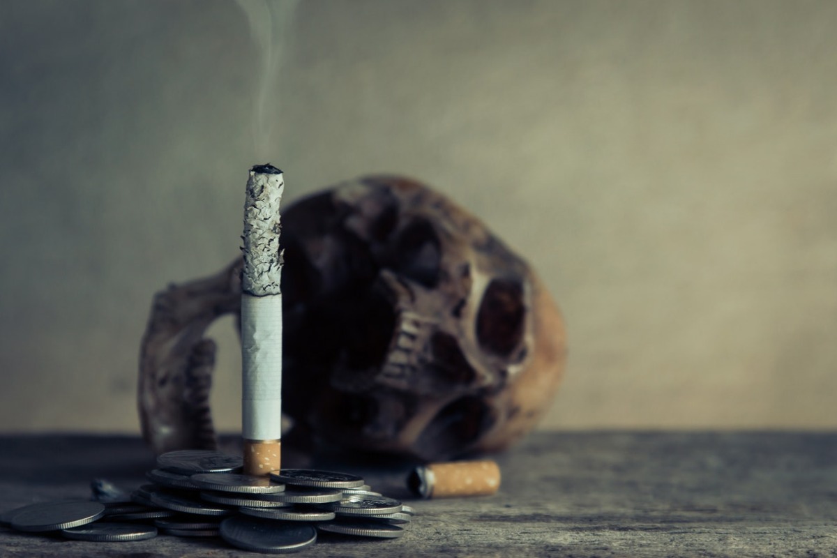 a cigarette, coins, and a skull