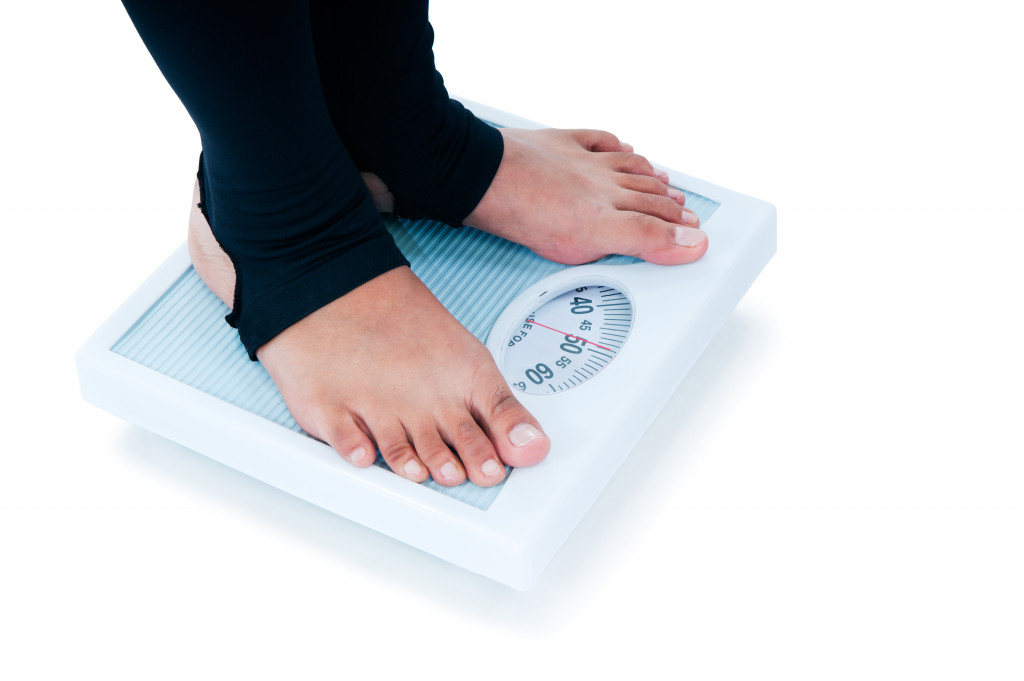 woman stepping on a weighing scale