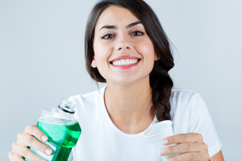 woman holding a bottle of mouthwash