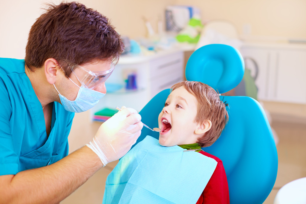 A pediatric dentist checking a child's teeth